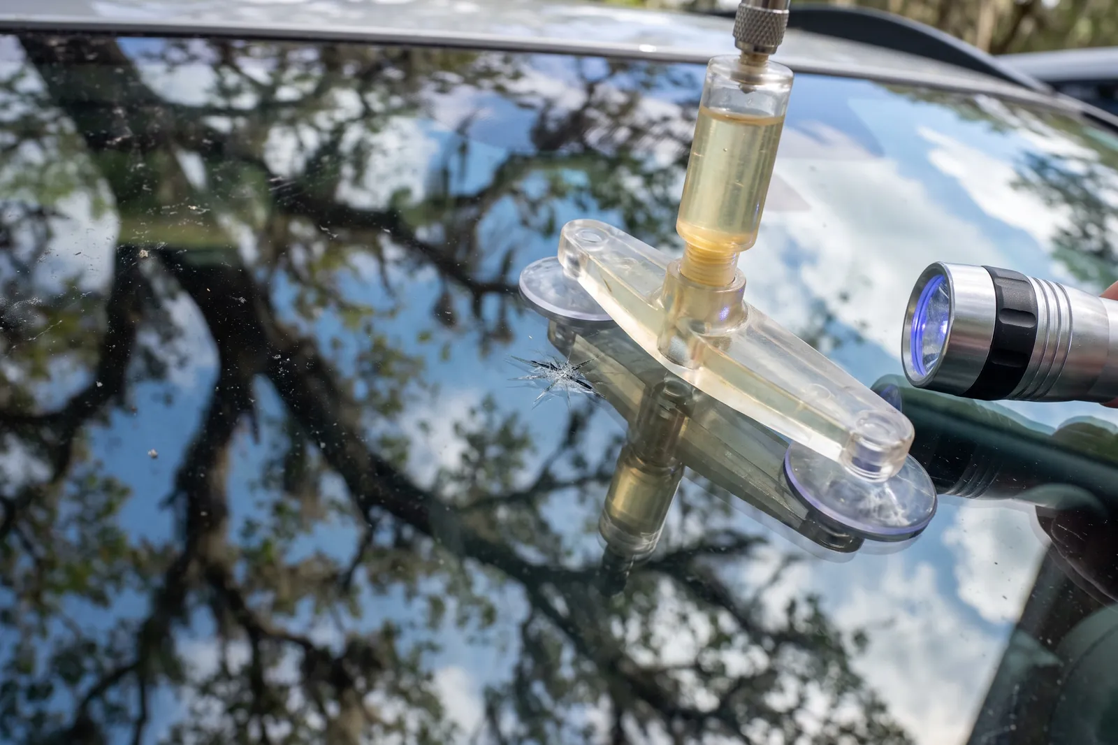 Resin injector tool set over a rock chip on a windshield